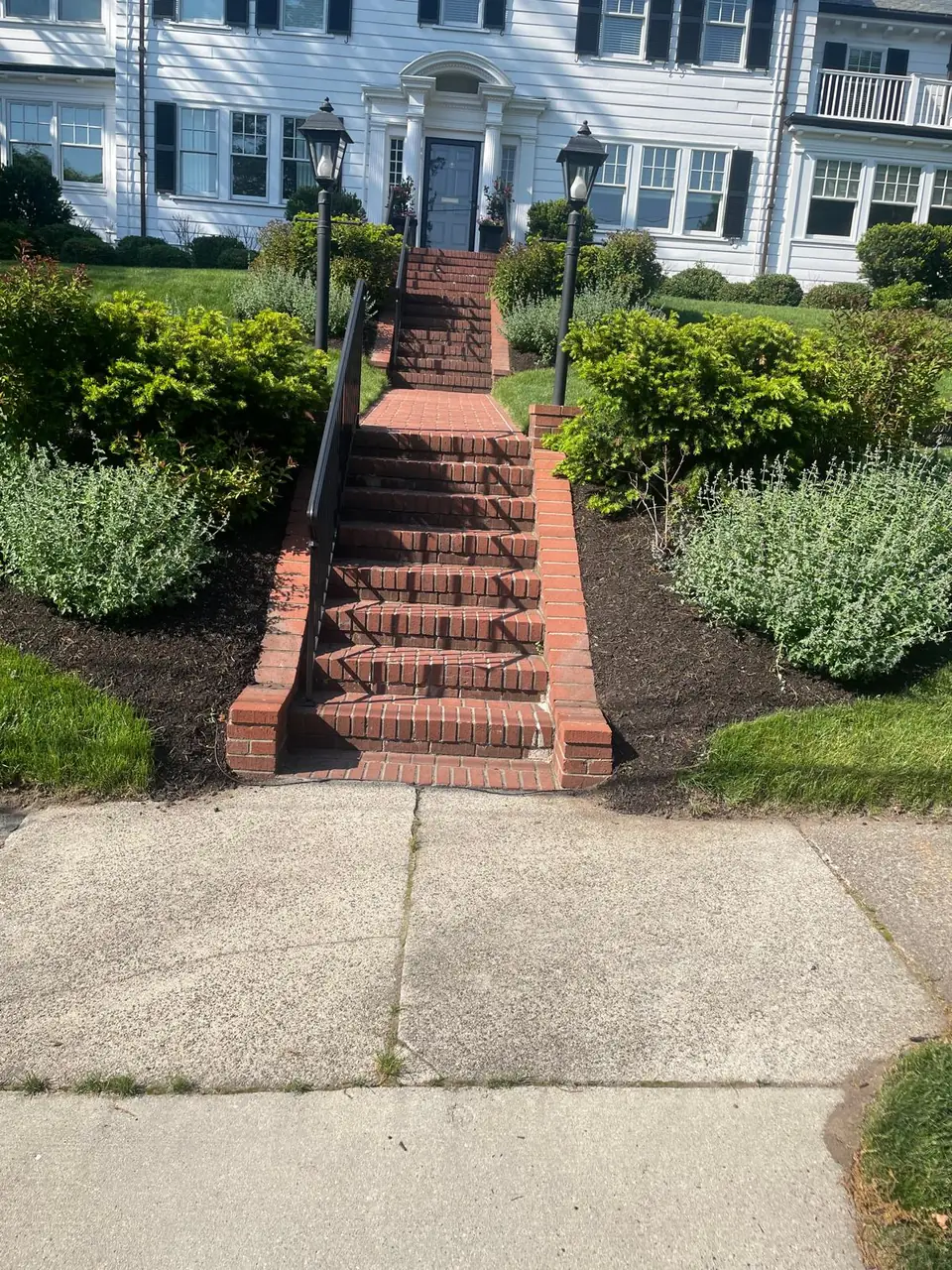 Brick entry steps framed by symmetrical mulched garden beds