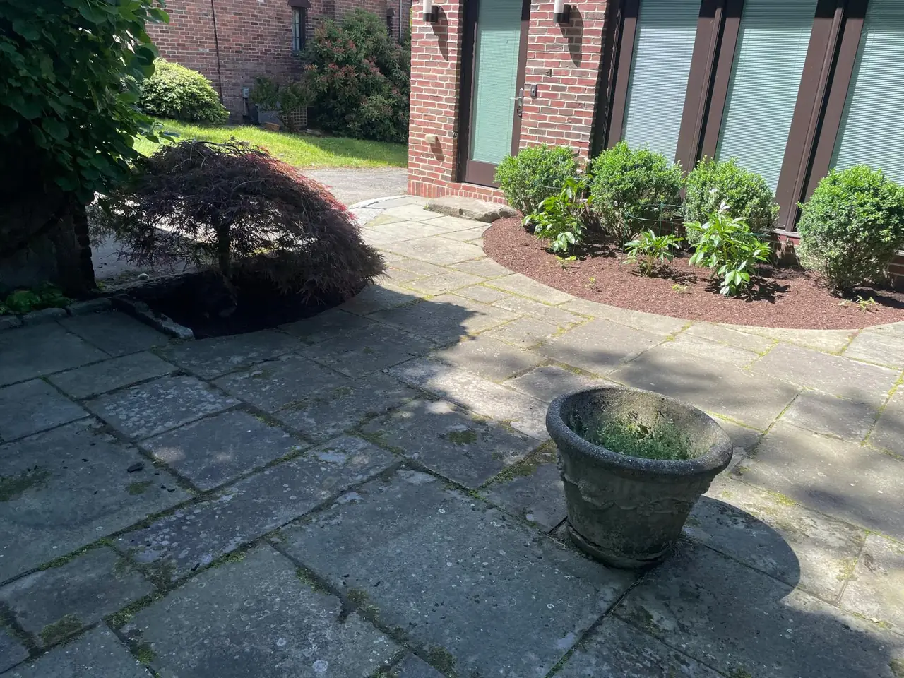 Curved mulched planting beds surrounding a stone courtyard