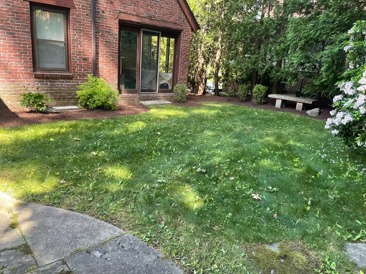Brick home with maintained lawn and freshly mulched perimeter beds