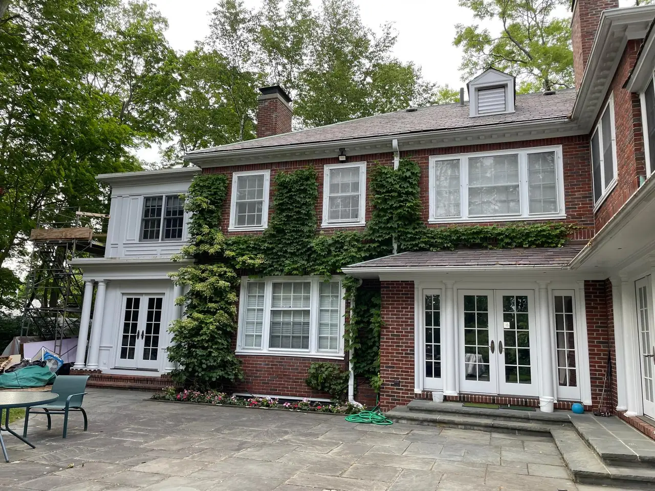 Brick home with climbing ivy and a broad stone patio